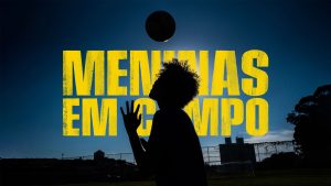 Logo for Meninas Em Campo, which features the words in large yellow typeface against a dark background with a silhouette of a girl heading a football in the air in the middle of the picture.