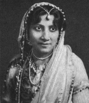 Image of Atiya Fyzee wearing a head-covering light-colored veil with a pearl ornament, and an embroidered/jeweled bodice.
